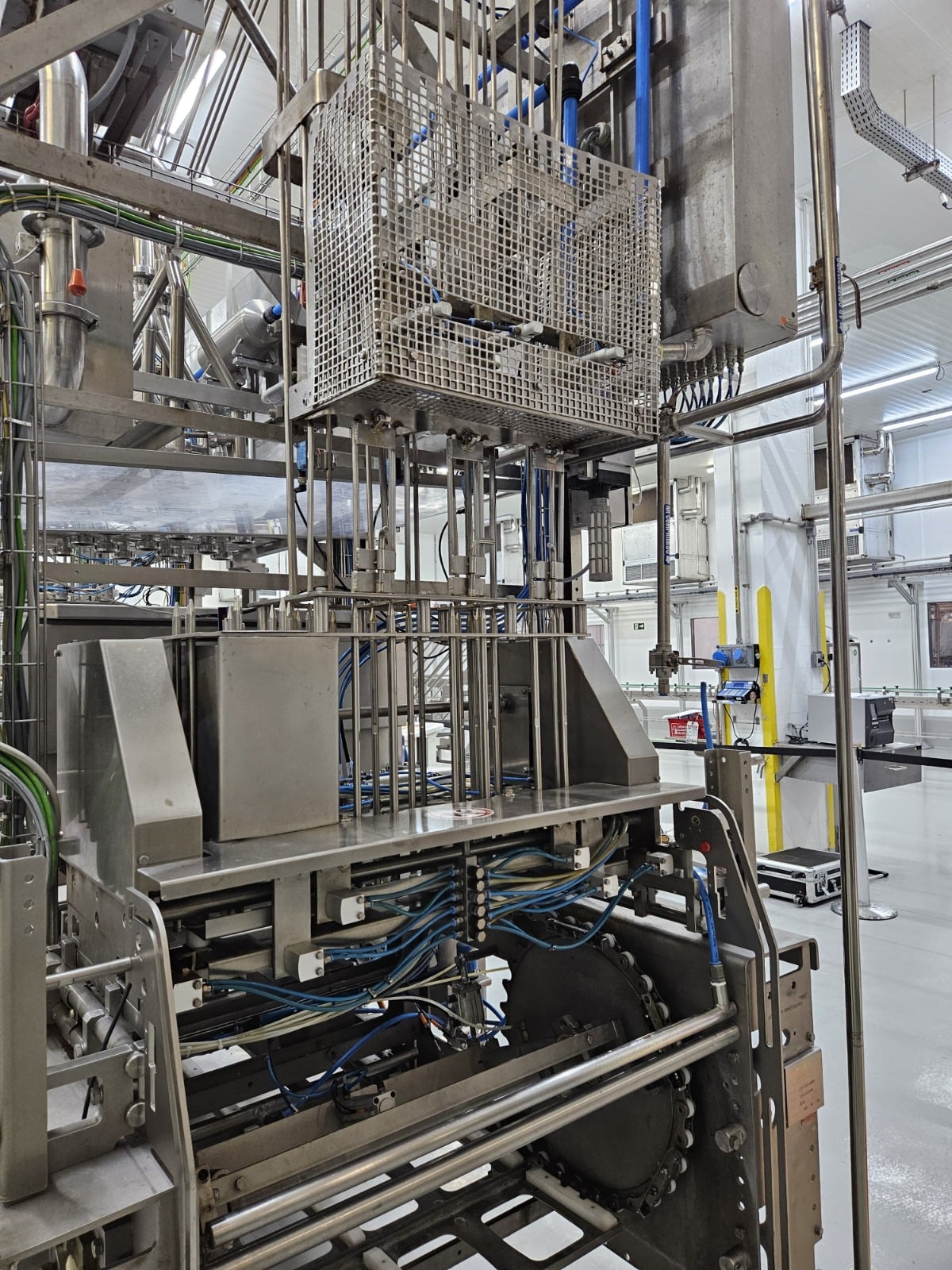 Equipamento industrial com estrutura metálica, tubulações e painéis de proteção